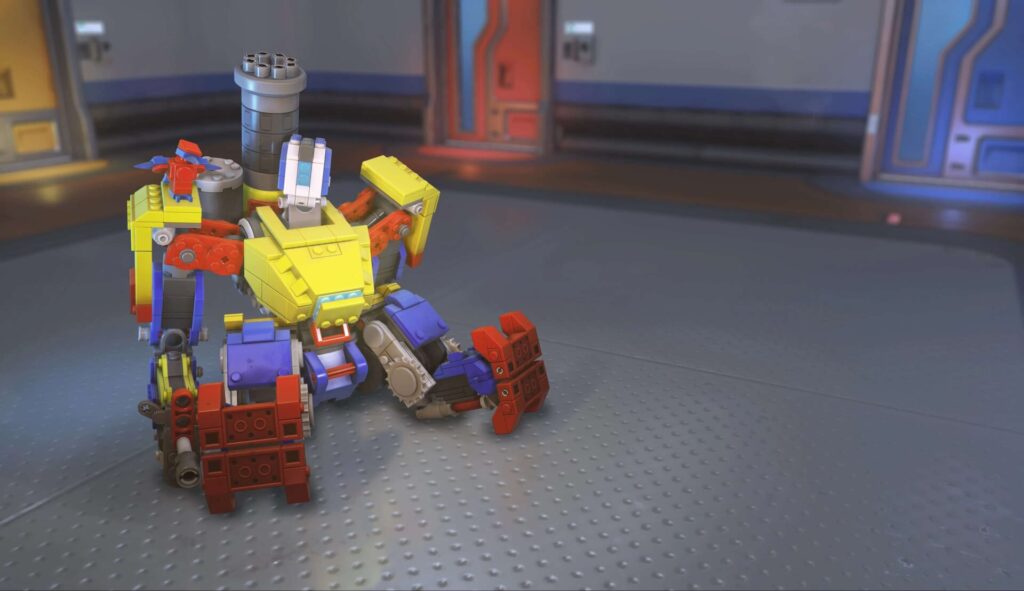Bastion in his Brick skin from Overwatch 2, designed to look like he's built from colorful toy bricks in red, yellow, blue, and gray, sitting in turret mode inside a futuristic room.