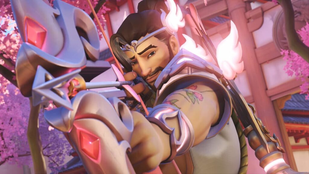 Hanzo in his Cupid skin from Overwatch 2, aiming a glowing pink arrow with a heart-shaped tip, wearing romantic-themed armor with winged accents, set against a backdrop of cherry blossoms and traditional Japanese architecture.