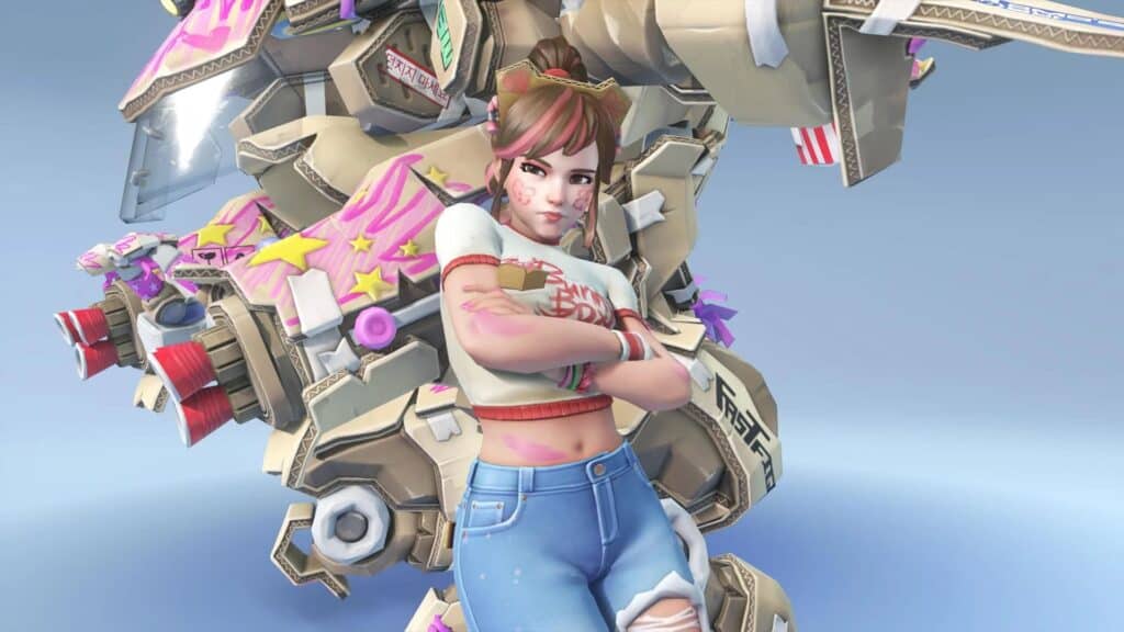 D.Va with pink face paint and cat ears crosses her arms, standing in front of a large, colorful mech